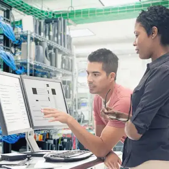 Image of two people analyzing data on a computer screen
